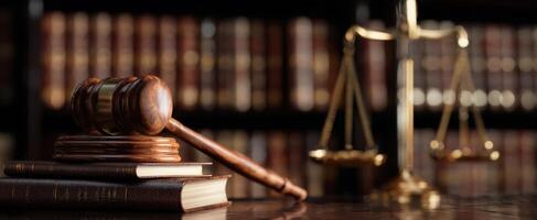 The gavel and scales of justice on a wooden desk in a law library. photo