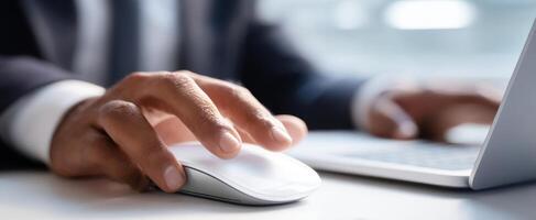 The hand using a mouse at a professional workspace with a laptop. photo