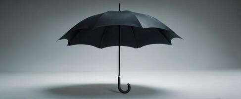 The elegant black umbrella standing alone against a minimalist background photo