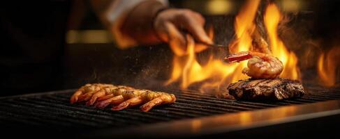 The chef grilling shrimp and steak over an open flame. photo
