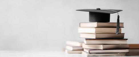 The graduation cap resting atop a stack of books symbolizes academic achievement. photo
