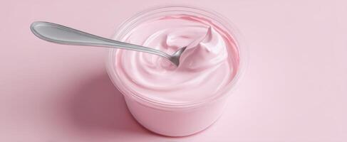 The creamy pink yogurt topped with a shiny spoon for delightful eating. photo