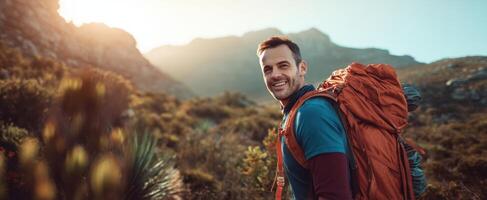 The smiling hiker enjoying a breathtaking mountain adventure at sunrise. photo