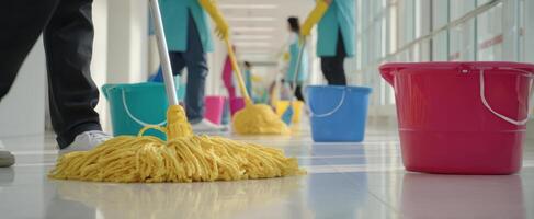 The mop cleaning a shiny floor in a busy corridor by professional staff. photo