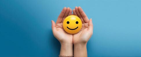 The hands holding a cheerful smiley face symbolizing positivity and joy. photo