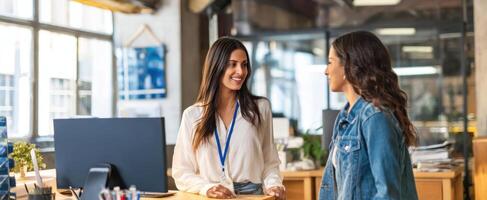 The friendly office interaction between two professional women in a modern workspace. photo