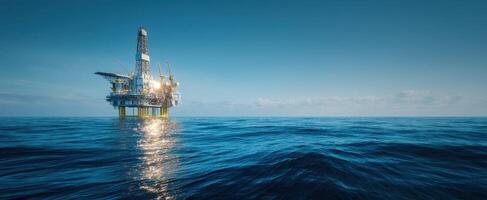 The offshore oil rig reflecting in calm ocean waters at dusk photo