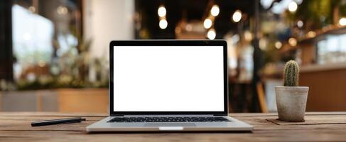 The modern laptop and cactus on a stylish wooden workspace. photo