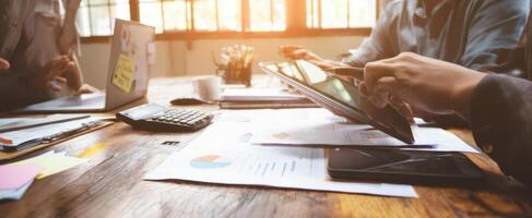 The collaborative workspace featuring a tablet and financial documents. photo