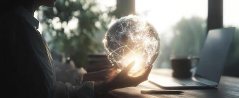 The glowing globe held by a person in a modern workspace environment. photo