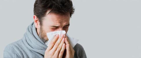 The man with a tissue expressing discomfort due to a cold or allergy. photo