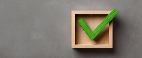The green checkmark inside a wooden box symbolizing approval and success. photo