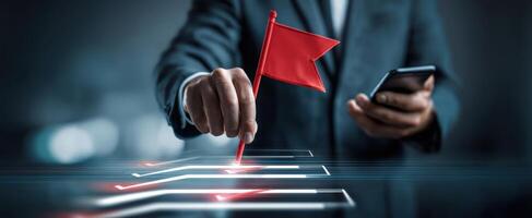 The businessman raising a red flag while using a smartphone for communication. photo