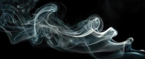 The graceful movement of smoke swirling elegantly against a black background. photo