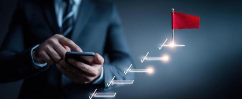 The businessman using a smartphone to track his progress towards success. photo