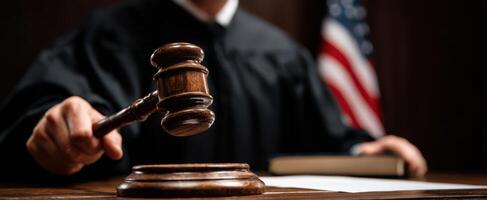 The judge holding a gavel in a formal courtroom setting. photo