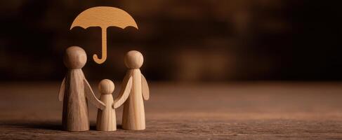 The wooden figures of a family under an umbrella symbolizing protection and love. photo