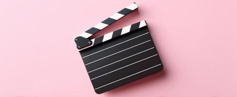 The classic clapperboard against a vibrant pink backdrop for filmmaking creativity photo