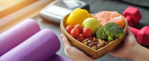 The heart-shaped bowl filled with healthy fruits and vegetables for fitness enthusiasts. photo