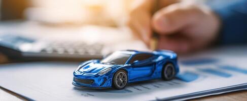 The stylish blue model car on financial documents and workspace. photo