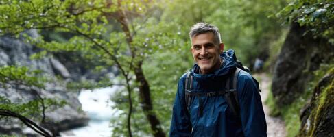 The joyful hiker enjoying nature by a scenic river in the forest. photo