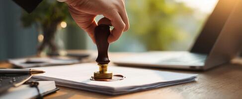 The professional application of a seal on important documents in a modern workspace. photo