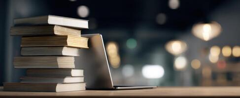The stack of books beside a sleek laptop in a modern workspace. photo