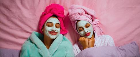 The two friends enjoying a relaxing spa night with face masks and towels. photo