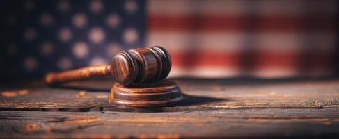 The gavel symbolizing justice set against a blurred American flag background. photo