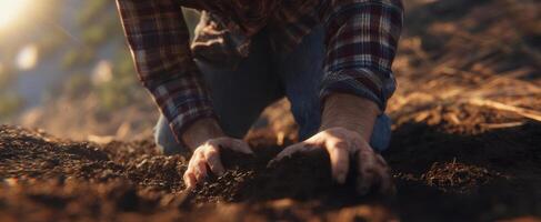 The hands of a farmer nurturing soil under warm sunlight in a tranquil landscape. photo
