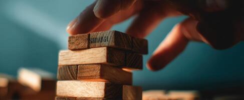 The hand skillfully stacking wooden blocks in a strategic game. photo