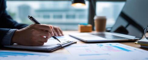 The focused hand writing notes on a business report at a modern desk. photo