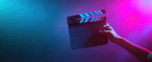 The clapperboard held in a colorful light atmosphere for filmmaking creativity. photo
