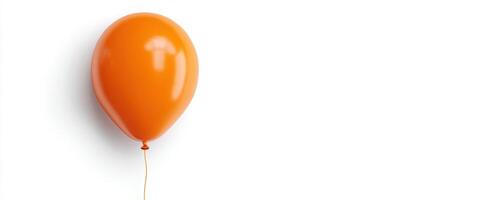 The vibrant orange balloon floating against a clean, white background. photo