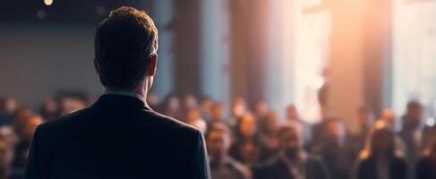 The speaker engaging an audience during a corporate presentation in a bright setting. photo