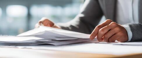 The hands sorting through a stack of documents on a professional desk photo