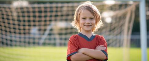 The confident child standing proudly in a soccer field with a bright smile. photo