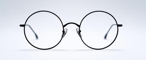 The elegant black round glasses on a minimalistic background shimmering. photo