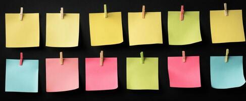 The colorful collection of sticky notes hanging on a black background. photo