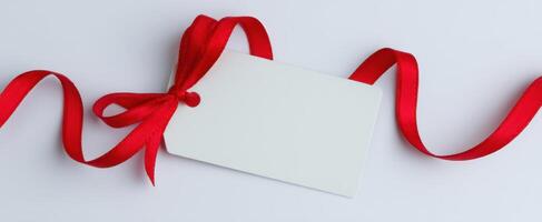 The blank gift tag adorned with a beautiful red ribbon for personalization. photo
