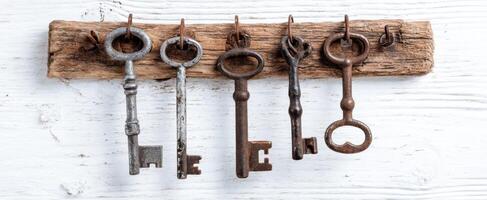The beautiful arrangement of vintage keys on a rustic wooden hanger. photo