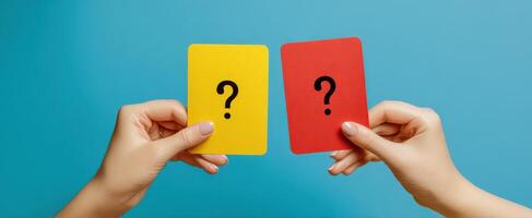 The hands holding yellow and red question cards against a blue background. photo