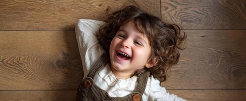 The joyful child lying on the floor with a beaming smile. photo