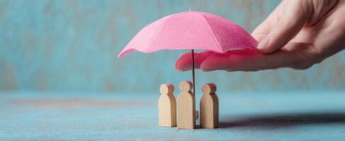 The umbrella providing protection to wooden figures representing community and care. photo