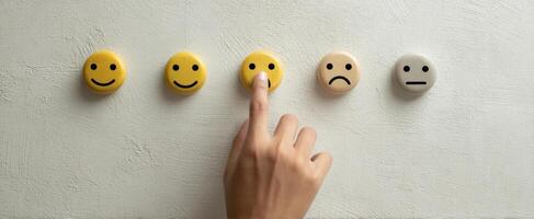 The hand selecting a smiley face among emotional icons on the wall photo