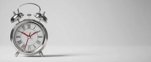 The vintage silver alarm clock showing precise time in a minimalist setting. photo