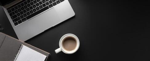 The laptop and coffee cup creating a minimalist workspace atmosphere. photo