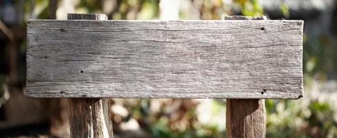 The weathered wooden signpost in a serene natural setting. photo