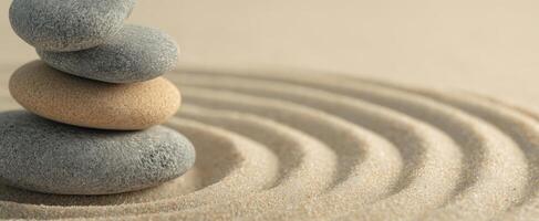 The serene arrangement of stacked stones on calming sand patterns. photo