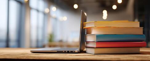 The laptop and stack of colorful books creating a modern workspace atmosphere. photo